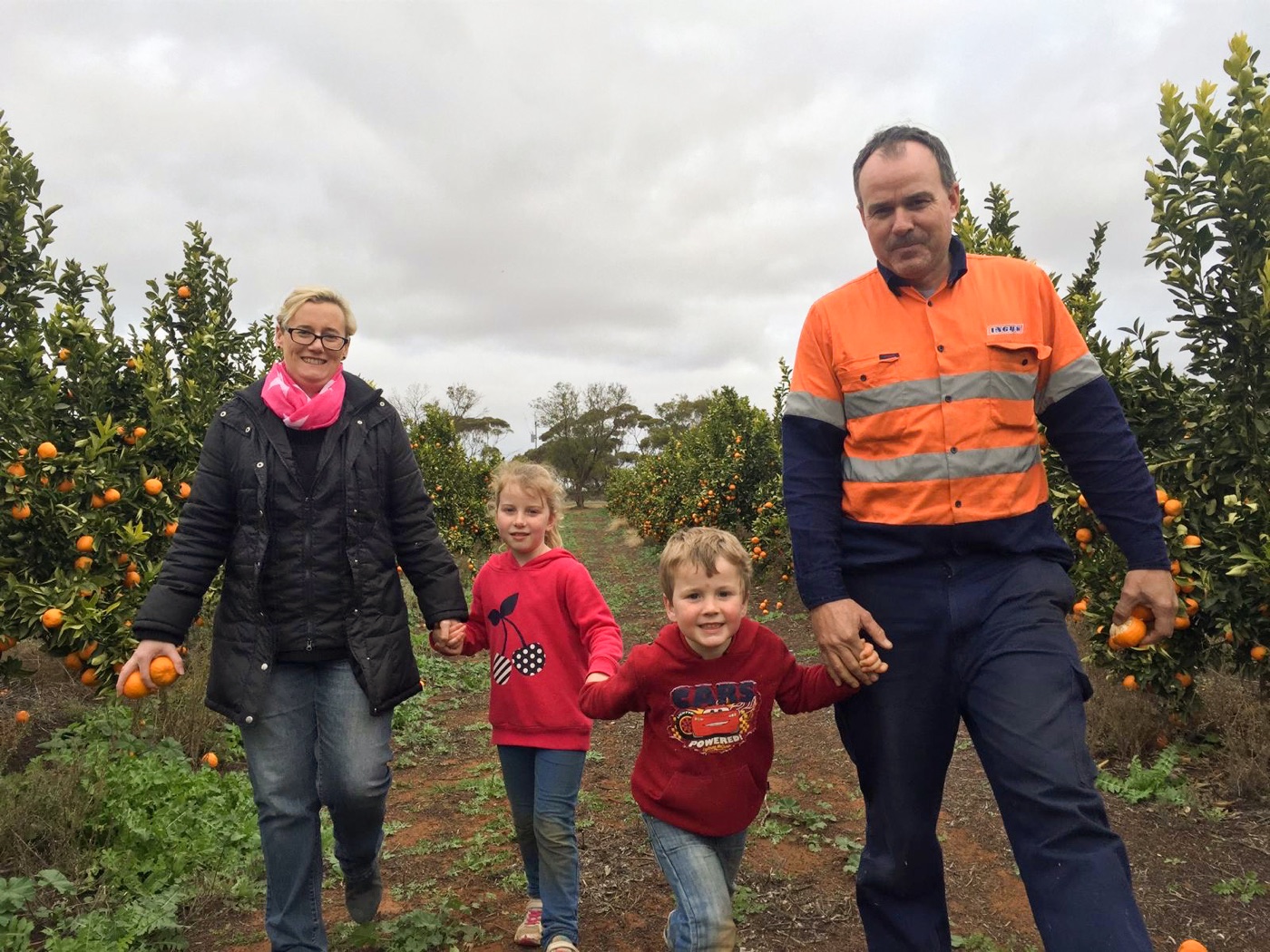 The family walking through the orchard
